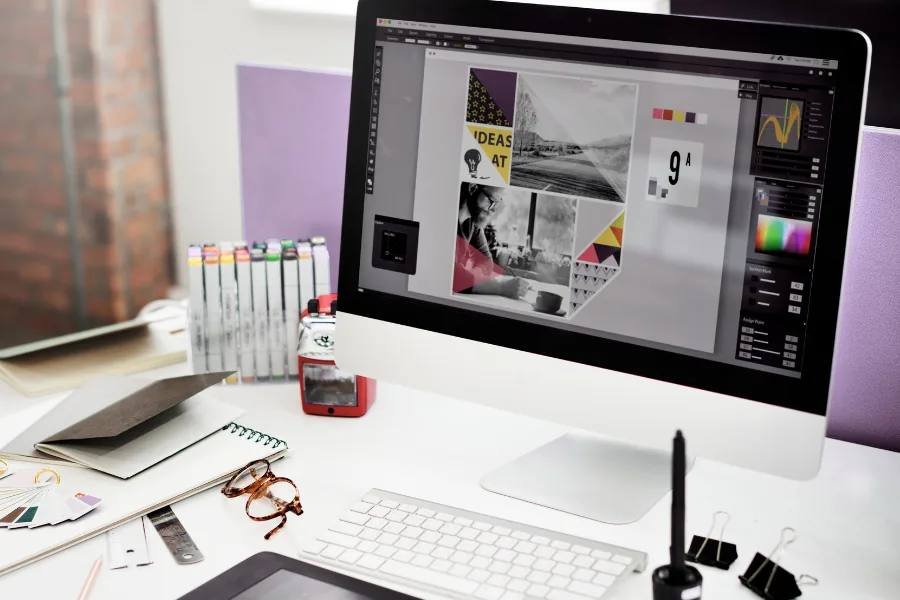Graphic design workspace — iMac, design software, and creative tools